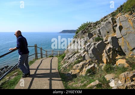 Mann mit Blick vom Wales Coast Path in der Nähe von Langland Bay, Gower Peninsula, Südwales. Stockfoto