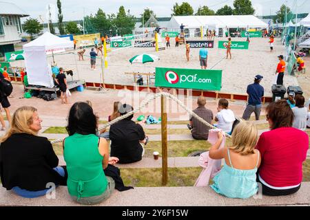GRUPPENSPIELE, OUTER COURT, BEACHVOLLEYBALL, MARIEHAMN, 2011: An einem ungewöhnlich heißen Sommertag in der Ostsee im August 2011 bei den PAF Open in Mariehamn, Åland, Finnland, beobachten die Menschen die Beachvolleyball-Action auf den Außenplätzen in Sommerkleidung oder Strandbekleidung. Foto: Rob Watkins. INFO: Das PAF Open Beach Volleyballturnier fand zwischen 2009-2013 in Mariehamn, Åland, Finnland statt. Es zog die besten internationalen Teams und Spieler als Rangliste der offiziellen FIVB World Tour an und zeigte hochkarätigen Beachvolleyball. Stockfoto
