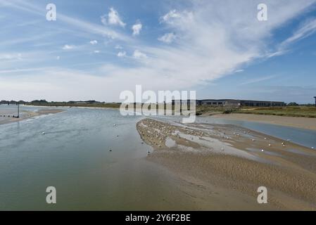 Die Mündung des Flusses Adur bei Shoreham in West Sussex, England. Mit neuen Lagerhäusern am Flughafen Brighton City. Ebbe. Vögel auf Schlammbänken. Stockfoto