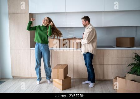 Eine überglückte Frau und eine glückliche Umsiedlung des Mannes. Lange erwartete Wohnung mit genehmigter Hypothek. Stockfoto