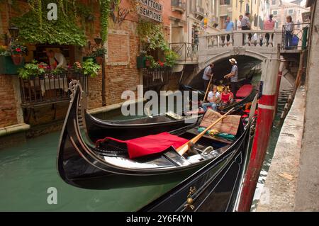 Zwei Gondeln passieren einander unter einer Brücke auf einem kleinen Kanal in Venedig Stockfoto