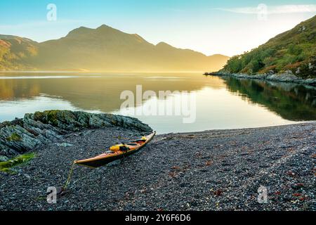 Ein Seekajak am Strand von Loch Hourn, Knoydart, Schottland, wenn die Dämmerung bricht Stockfoto