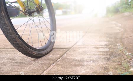 Rad eines Fahrrads ist flach parken auf einem BetonGehsteig neben einer Straße, muss repariert werden, der Moment der Stille und eine unerwartete Pause auf einer Reise Stockfoto