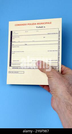 Verkehrsfahrkartenverletzung Polizeiverbrechen in Italien, Mann Hand hält leer mit blauem Hintergrund Stockfoto