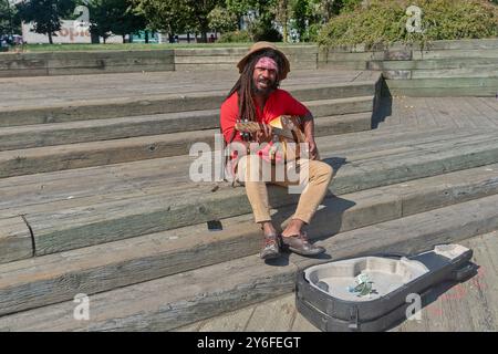 Straßensänger mit Gitarre auf dem Damm. Halifax, Nova Scotia, Kanada Stockfoto