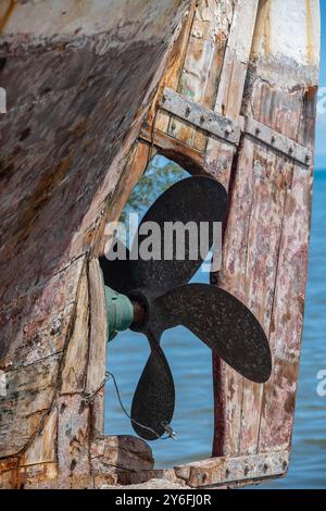 Das Wetter war überfordert und verstört altes Schiff oder Bootspropellor und hölzerne Ruder an Land in einem Hafen auf der griechischen Insel Zante oder Zakynthos. Stockfoto