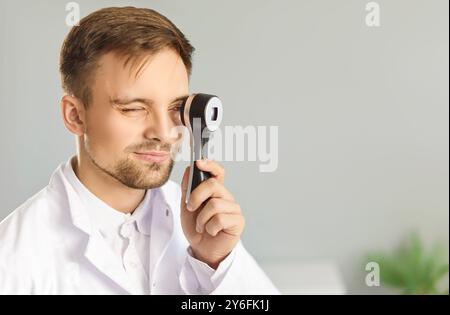 Nahporträt eines in der Klinik stehenden Arztdermatologen, der das Dermatoskop in der Hand hält Stockfoto