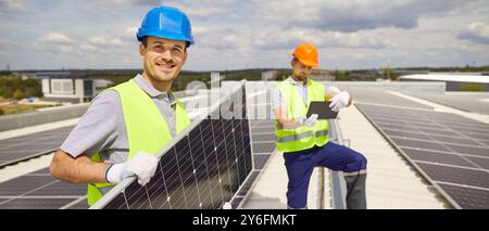 Team von Elektroingenieuren, die Photovoltaik-Solarpaneele installieren und die Kamera betrachten. Stockfoto