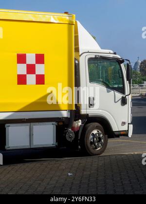 Gelb-weißer Lieferwagen parkt an einem sonnigen Tag. Der Stapler ist leer und bereit für die Beladung mit Waren zur Auslieferung Stockfoto