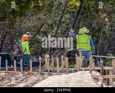 Georgetown, TX – 19. September 2024: Gräben im Sand für Sanitär- und Abflussleitungen werden mit Beton als Basis der Fundamentplatte gefüllt. Stockfoto