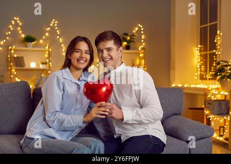 Porträt Eines Glücklichen Paares, Das Am Valentinstag Einen Herzballon Hält Stockfoto