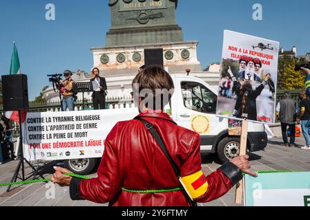 Ich spreche auf dem Truck mit einem Poster, Femme Vie Liberte, mit einem Poster im Vordergrund von hinten, Nein zur Islamischen republik im Iran. Frau Leben Freiheit. Demonstrationen anlässlich der zwei Jahre seit der Ermordung von Jina Mahsa Amini am 16. September 2022 in Teheran und zur Unterstützung des iranischen Volkes bei seinem Streben nach Freiheit, Säkularismus und Demokratie. Frankreich, Paris, 15. September 2024. Foto: Patricia Huchot-Boissier / Agence DyF. Stockfoto