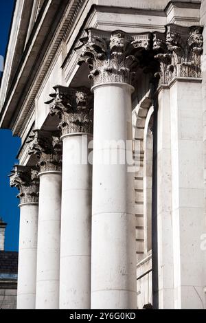 Die eleganten neoklassizistischen Säulen des Trinity College zeigen komplizierte Details vor einem klaren blauen Himmel in Dublin. Stockfoto