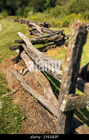 Eine Nahaufnahme eines alten zerfallenen, geteilten Schienen-Holzzauns im Zickzackmuster. Stockfoto