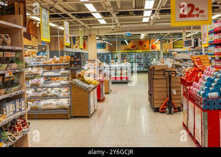 Innenansicht des Supermarkt-Bäckereibereichs mit Brotdisplays und Produktregalen. Stockfoto