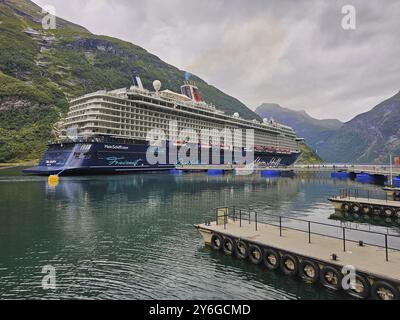 Ein großes Kreuzfahrtschiff, mein Schiff 6, liegt im Fjord, umgeben von grünen Bergen unter bewölktem Himmel, mit Catwalk, Geiranger, Geiranger Fjord, Str. Stockfoto