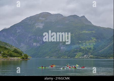 Mehrere Kajakfahrer in einem Fjord umgeben von bewaldeten Bergen und Wolken, Geiranger, Geiranger Fjord, Stranda, Romsdal, Norwegen, Europa Stockfoto