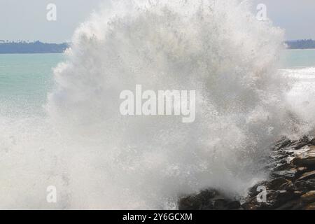 Große Meereswelle bricht auf den Felsen der tropischen Küste Stockfoto