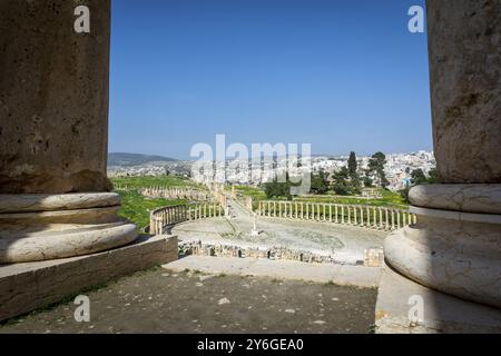 Griechisch-römische Ruinen von Gerasa und die moderne Stadt Jerash im Hintergrund. Oval Forum, Säulenstraße und Cardo Maximus in freier Sicht Stockfoto