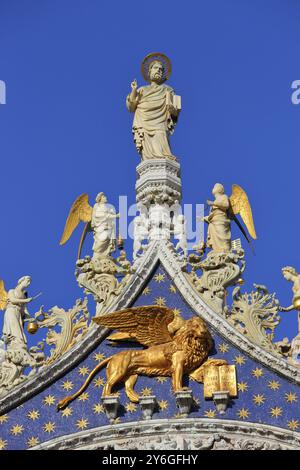 Skulptur Markusdom, Engel und Löwe auf der Spitze der Markusdom-Fassade (Markusdom) in Venedig, Italien. Der geflügelte Löwe ist es Stockfoto