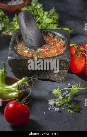 Essen, traditionelle lateinamerikanische mexikanische Tomatensauce Salsa, chilenische Chancho en piedra in Steinmörtel Stockfoto