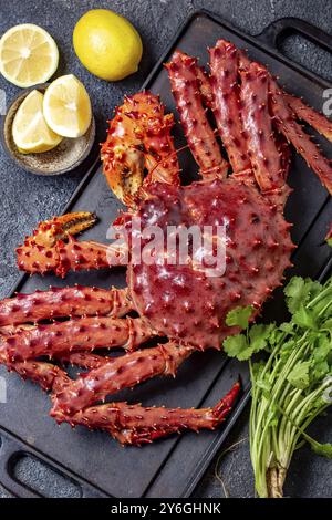 Essen, Essen, Rote Königskrabbe auf grauem Hintergrund. King Crab, Zitrone und Koriander, Blick von oben Stockfoto