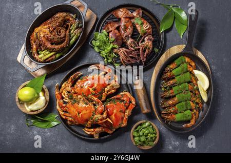 Essen, Essen, gedeckter Tisch mit Meeresfrüchten, gekochten Krabben, Tigergarnelen, gegrillten Oktopus und Tintenfischen auf gusseiserner Pfanne Stockfoto