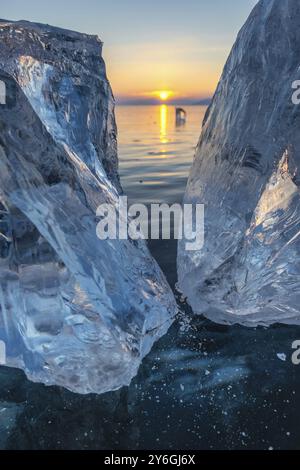 Sonnenuntergang auf der gefrorenen Landschaft des Lake Baikal, Sonnenlicht wird in Eisstücken gebrochen Stockfoto