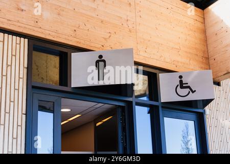 Moderner Eingang für öffentliche Toiletten mit zwei Schildern, eines für Männer und eines für barrierefreie Toiletten Stockfoto