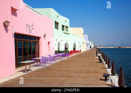 Farbenfrohe Restaurants und Cafés entlang der Promenade des alten Hafens von Doha in Doha, Katar Stockfoto