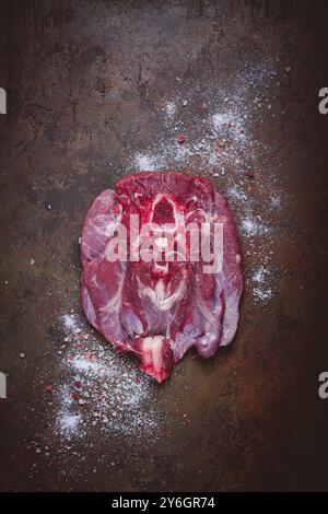 Essen, rohes Steak, Kalbshals auf dem Knochen, frisches Fleisch, auf dem Tisch, mit Gewürzen, Blick von oben, keine Personen Stockfoto