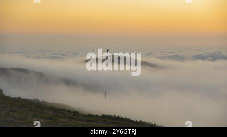 Blick auf den Sonnenuntergang auf den Berg Foia in Mochique, Portugal, während des Sonnenuntergangs mit Wolken hereinrollen und die Gipfel mit Nebel bedecken, Europa Stockfoto