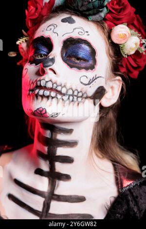 Kopffoto-Porträt einer Frau, die im Kostüm „Tag der Toten“ gekleidet ist und Dia de los Muertos feiert. Nahaufnahme eines Mädchens, das furchterregendes Skelett-Make-up trägt, das die mexikanische Kultur während Halloween fördert Stockfoto