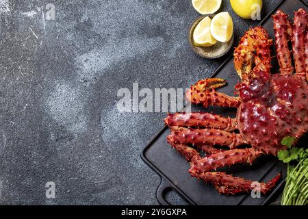 Essen, Essen, Rote Königskrabbe auf grauem Hintergrund. King Crab, Zitrone und Koriander, Blick von oben Stockfoto