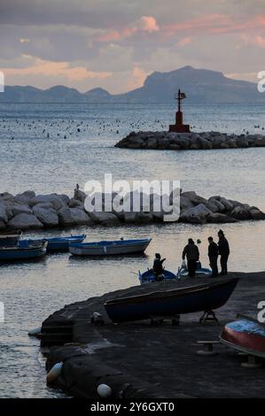 Fischer bei Sonnenuntergang am Strand Colonna Spezzata an der Küste von Neapel mit Blick auf Capri Stockfoto