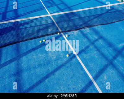 Fünf Bälle in der Nähe des Netzes in einem Padel Tennis Blue Rasen Platz, aus der Vogelperspektive Stockfoto