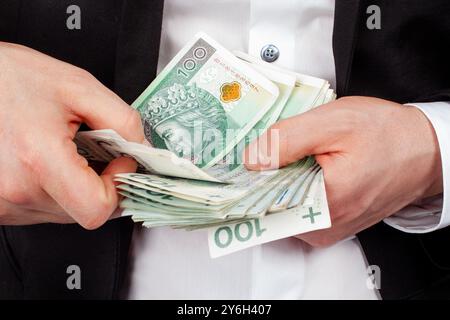 Geschäftsmann zählt einen Stapel polnischer Zloty-Banknoten Stockfoto