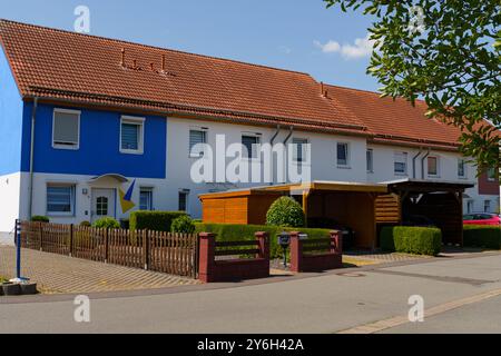 Waltershausen, Deutschland - 11. Juni 2023: Eine schöne Wohnanlage in Waltershausen zeigt eine leuchtend blau-weiße Fassade. Der Garten ist gepflegt Stockfoto