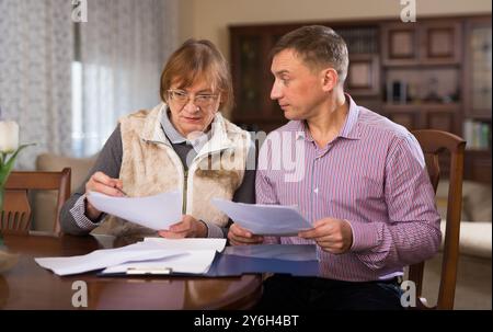 Frau mit Sohn, die Dokumente ausfüllt Stockfoto