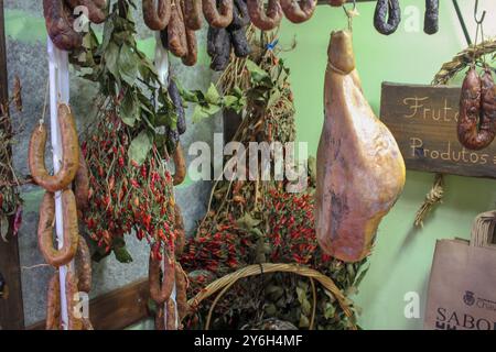 Schweineprodukte hängen in einem traditionellen Geschäft in Chaves, Portugal Stockfoto