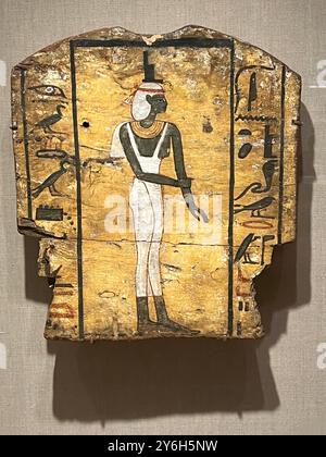 Sargfragment mit Trauer Isis, ca. 664–332 v. Chr. Holz, Pigment, ägyptisch, 14 3/16 x 12 5/8 Zoll (36 x 32 cm). Brooklyn Museum, ein Fuß eines anthropoiden Sargdeckels, mit einem polychromen Bild der Göttin Isis. ISIS schreitet nach links, ihre rechte Hand schließt ihr linkes Handgelenk in einer Geste der Trauer. Sie trägt ein dünnes Neckholder-Kostüm ohne Oberteil. Ein breiter Kragen, eine Taschenperücke und zwei Armbänder runden das Kostüm ab. Die Figur wird auf beiden Seiten von einer Spalte mit Hieroglyphen flankiert. Stockfoto