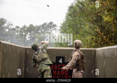 Jacksonville, North Carolina, USA. September 2024. Christopher Andujarmayas, ein Datensystemadministrator der 2nd Air Naval Gunfire Liaison Company, II Marine Expeditionary Force Information Group, weist ein finnisches Dienstmitglied über die richtigen Granatwurftechniken während der Burmese Chase 24 im Marinekorps Base Camp Lejeune, North Carolina, am 16. September 2024 an. Burmese Chase ist eine jährliche, von den USA geführte, multilaterale Übung, bei der neben NATO-Verbündeten Schulungen zur Integration von Boden- und Luftfeuern, Infanterie-Taktiken und Marineschusswaffen durchgeführt werden. (Kreditbild: © Jac Stockfoto