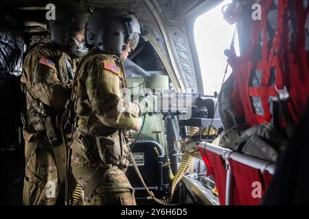 US-Soldaten, die der Bravo Company 5-159, 244th Expeditionary Combat Aviation Brigade, zugeteilt wurden, füttern und feuern ein mittleres Maschinengewehr M240B aus einer CH-47F Chinook auf dem Bombenziel 11, North Carolina, 14. September 2024. Die 244th Aviation Brigade nutzt MCOLF Atlantic für alle zwei Jahre, um die Einsatzfähigkeit und Kampfbereitschaft zu erhalten. (Foto des U.S. Marine Corps von Lance CPL. Michail Stankosky) Stockfoto