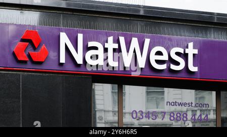 London, Großbritannien - 21. September 2024; Schild mit Logo auf der Fassade der Bankfiliale NatWest mit Kontaktnummer Stockfoto