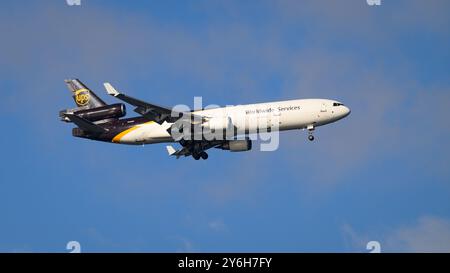 Seattle - 18. August 2024; UPS United Parcel Service Lackierung Boeing McDonnell Douglas MD 11 Tri Jet fliegt mit abgesenkten Rädern gegen blauen Himmel Stockfoto