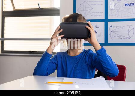 Mit dem VR-Headset erkundet der Junge die virtuelle Realität im Klassenzimmer Stockfoto