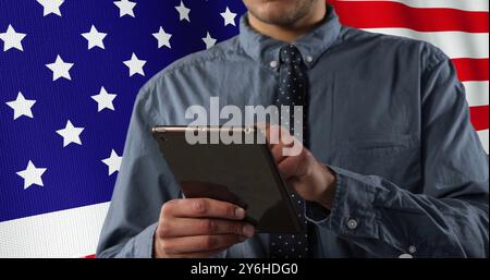 Bild der Flagge der usa über glücklichem kaukasischen Geschäftsmann mit Tablet Stockfoto