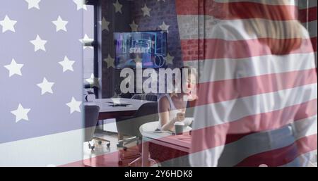 Amerikanisches Flaggenbild über Geschäftsfrau, die am Schreibtisch in einem modernen Büro arbeitet Stockfoto