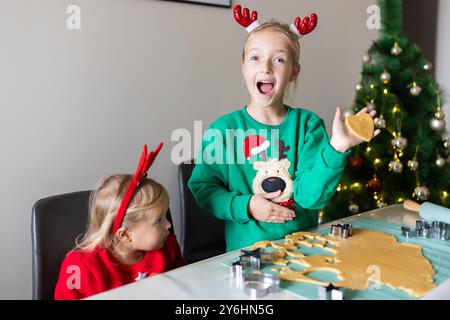 Zwei kaukasische Schwestern bereiten Lebkuchenkekse zu Weihnachten zu Hause vor Stockfoto