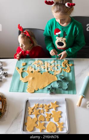 Zwei kaukasische Schwestern bereiten Lebkuchenkekse zu Weihnachten zu Hause vor Stockfoto